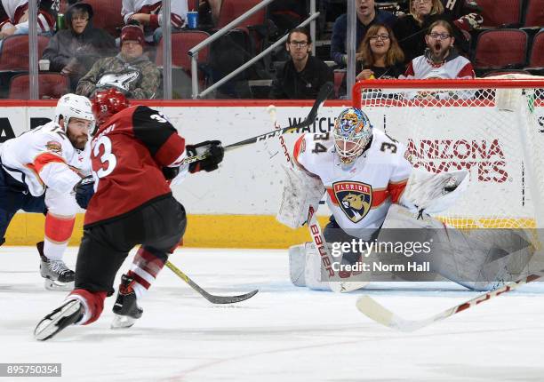 Goalie James Reimer of the Florida Panthers makes a glove save on the shot by Alex Goligoski of the Arizona Coyotes as Ian McCoshen of the Panthers...