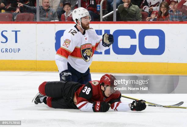 Nicholas Merkley of the Arizona Coyotes and Ian McCoshen of the Florida Panthers look for the puck after colliding during the third period at Gila...