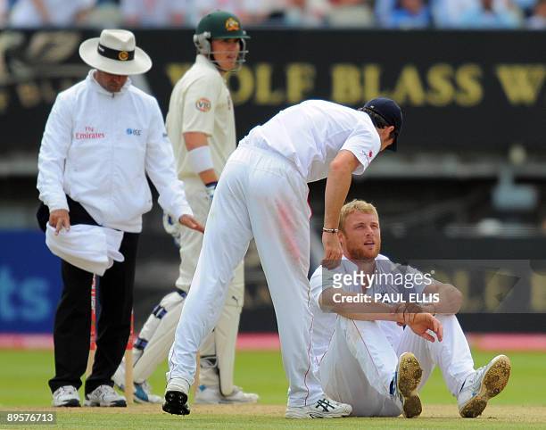 England fielder James Anderson checks on England bowler Andrew Flintoff after he fell to the ground while bowling on the final day of the third Ashes...