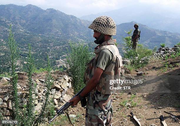 Pakistani Army soldiers look on from a mountain during a patrol in the troubled area of Maidan in the district of Lower Dir on August 3, 2009....