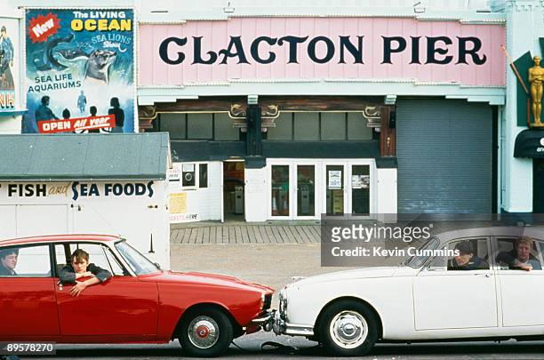 English pop group Blur in two cars, a Rover P6 and a Jaguar Mark 2, at Clacton Pier, Clacton-on-Sea, Essex, March 1993. Left to right: guitarist...