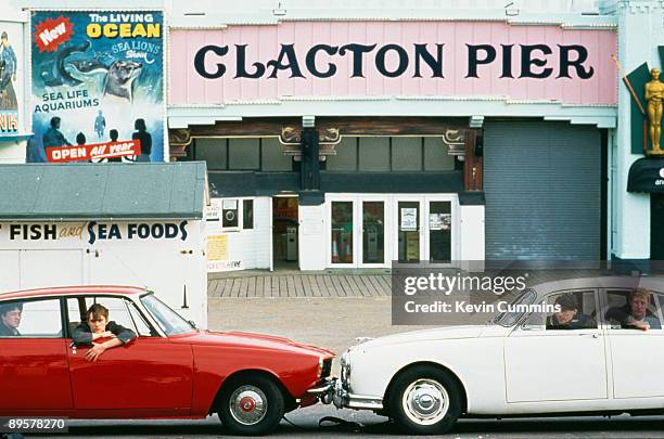 English pop group Blur in two cars, a Rover P6 and a Jaguar Mark 2, at Clacton Pier, Clacton-on-Sea, Essex, March 1993. Left to right: guitarist...