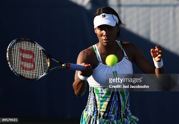Venus Williams returns a shot during her doubles match with her sister Serena Williams, against Yi Chen of Taipei and Mashona Washington during the...