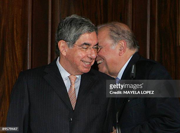 Costa Rican President Oscar Arias and Ibero American Secretary, Enrique Iglesias, joke during a press conference at Arias's residence in San Jose on...