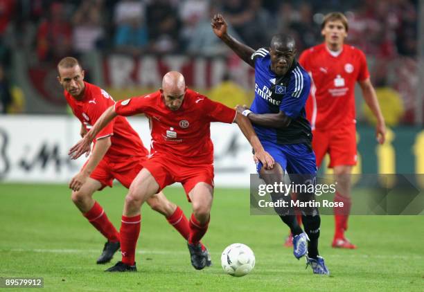 Stephan Sieger of Duesseldorf and Guy Demel of Hamburg compete for the ball during the DFB Cup first round match between Fortuna Duesseldorf and...