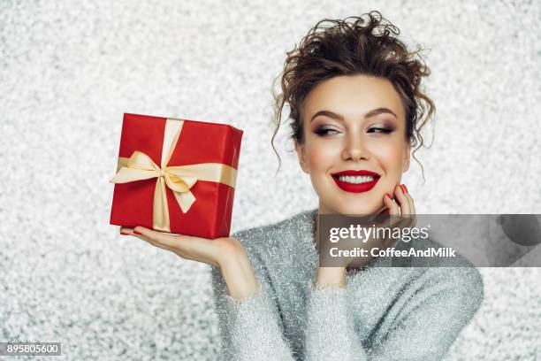 christmas happy smiling young woman holds gift box in hands - christmas surprise stock pictures, royalty-free photos & images