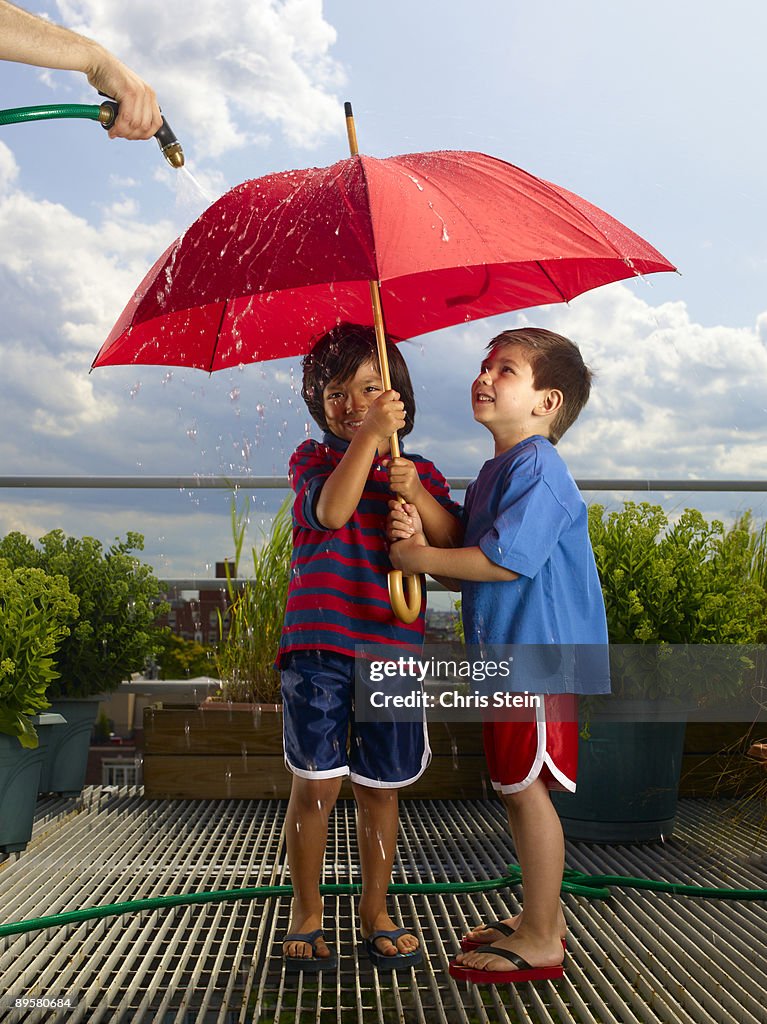 Two Young Boys playing with an umbrella