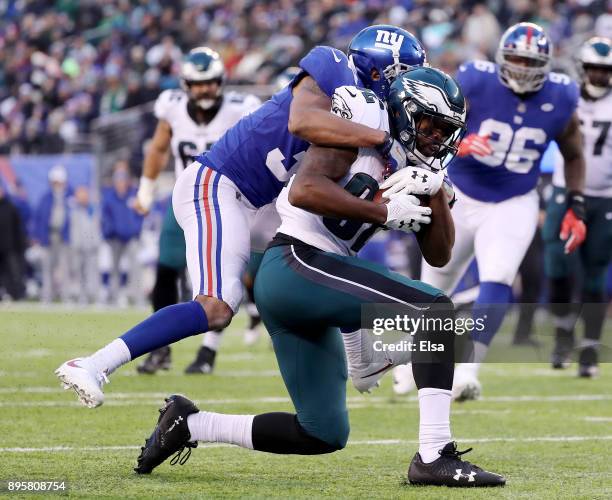 Torrey Smith of the Philadelphia Eagles is tackled by Ross Cockrell of the New York Giants in the fourth quarter at MetLife Stadium on December 17,...