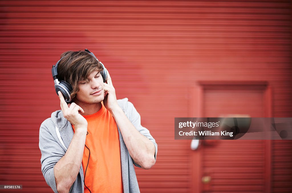 Young adult listening to music on headphones