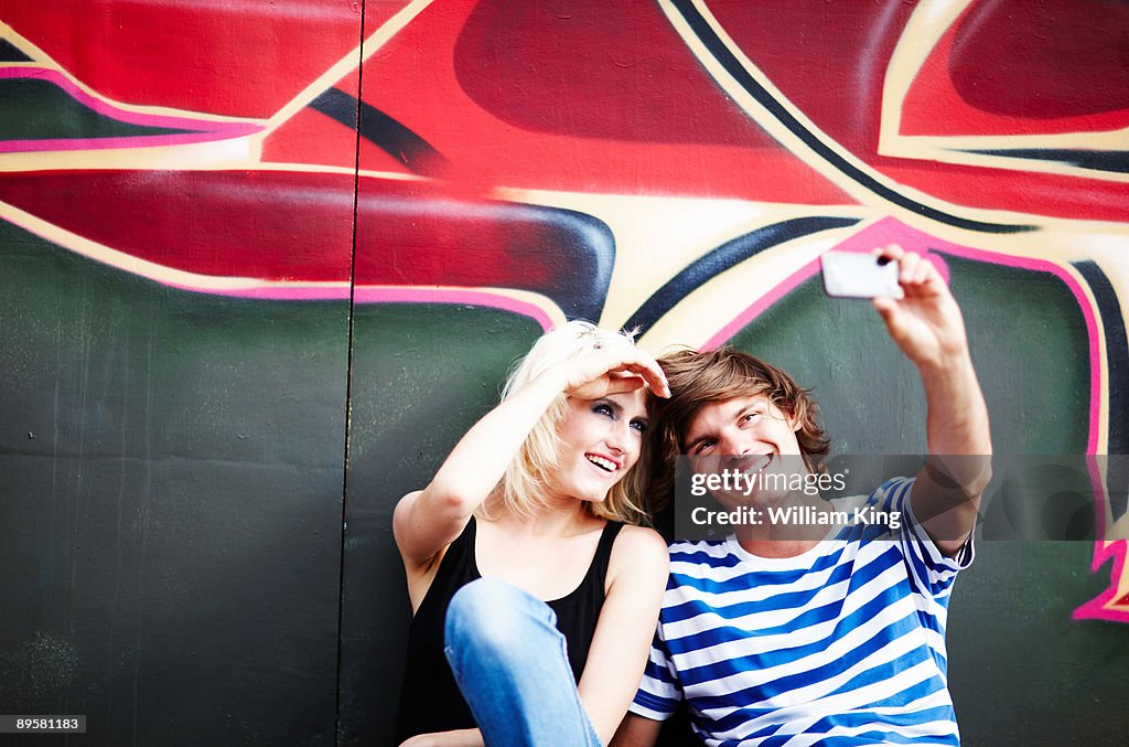 Couple taking self portrait using mobile phone