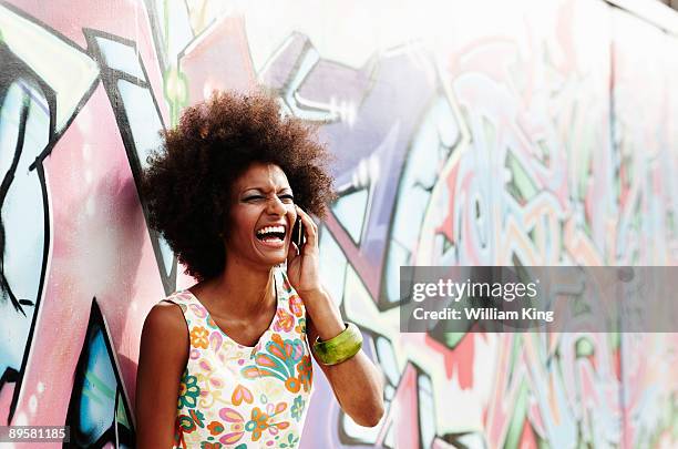 girl laughing on mobile in urban setting - bristol stock-fotos und bilder