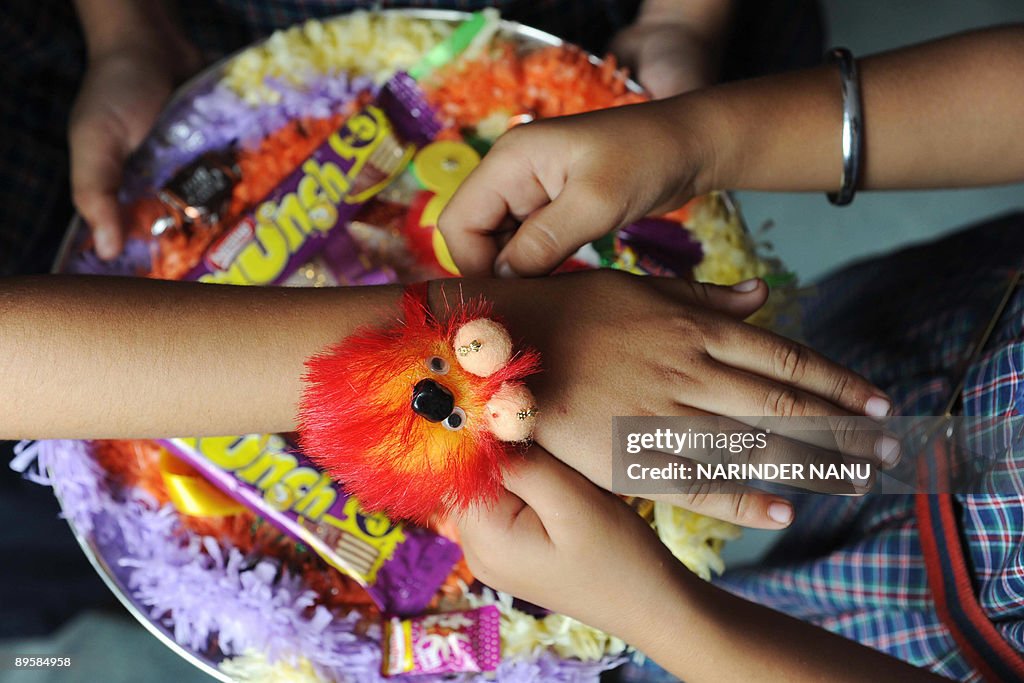 Indian children tie 'rakhis' (sacred thr