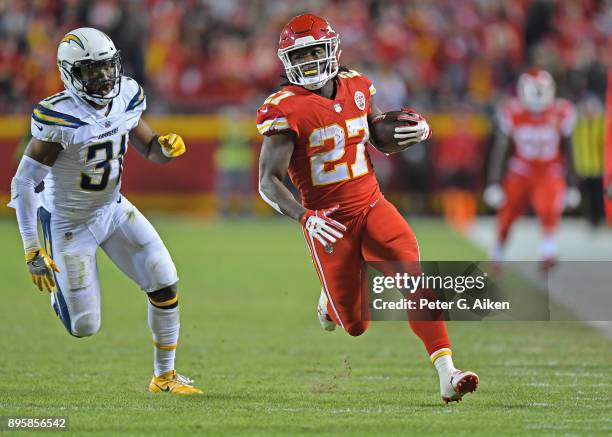 Running back Kareem Hunt of the Kansas City Chiefs runs up field past free safety Adrian Phillips of the Los Angeles Chargers during the first half...