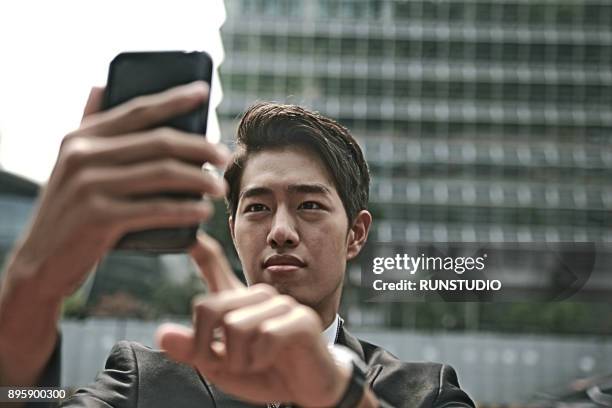 businessman using cell phone on city street - wap stock pictures, royalty-free photos & images