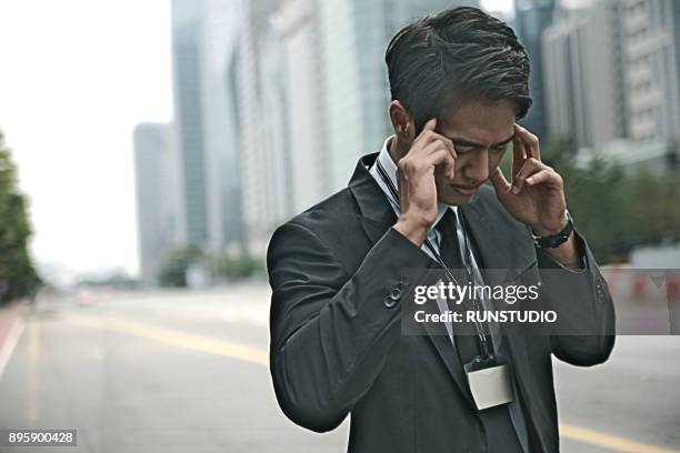 businessman with headache outdoors - seoul special city stock pictures, royalty-free photos & images