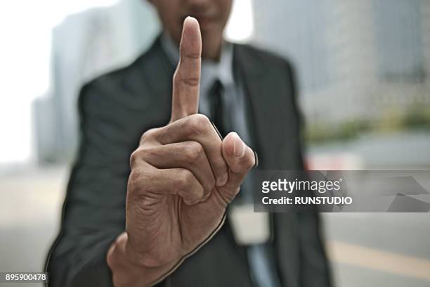 midsection of businessman pointing index finger - index finger stock pictures, royalty-free photos & images