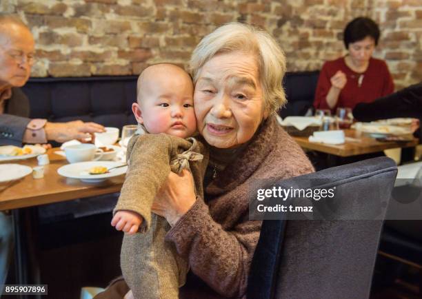 90 years old and 0 years old, at family celebration. - t maz stock pictures, royalty-free photos & images