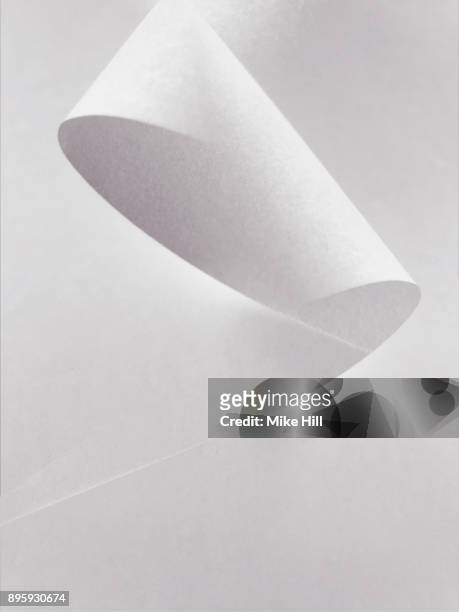multiple exposure image of a curled sheet of white paper - bent imagens e fotografias de stock