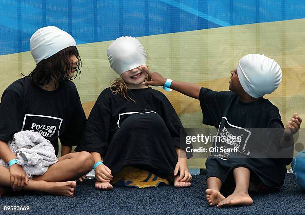 School children play with their swimming caps as they wait for Rebecca Adlington and Boris Johnson to help launch the "Pools 4 Schools" initiative at...