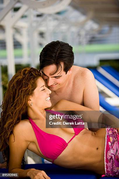 young hispanic couple on lounge chairs.  - derek latta stock-fotos und bilder