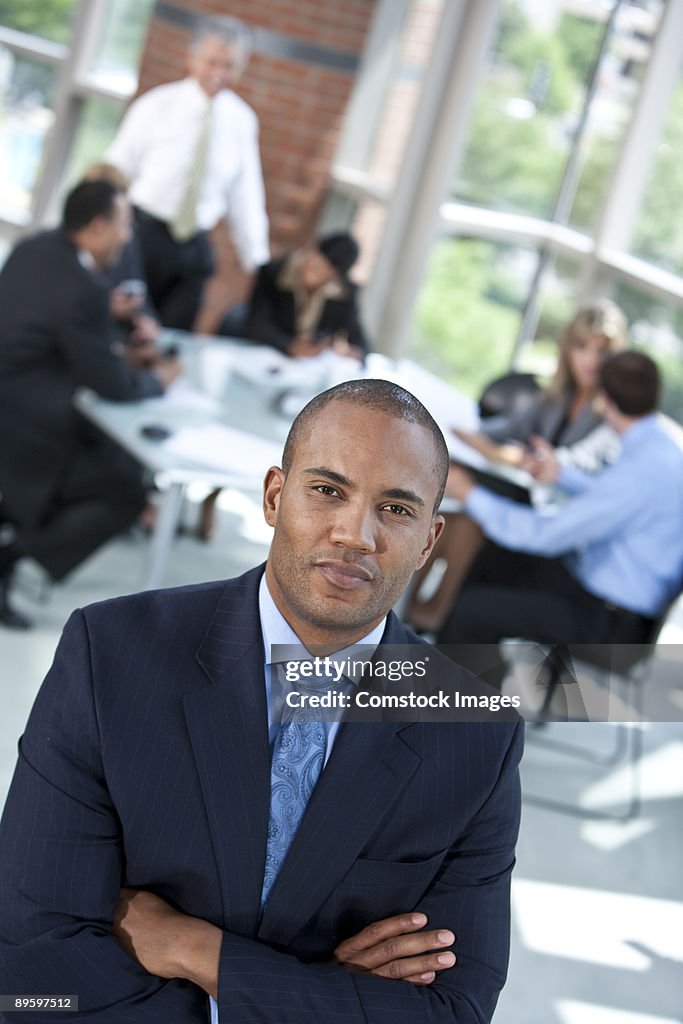 Man with arms crossed at meeting