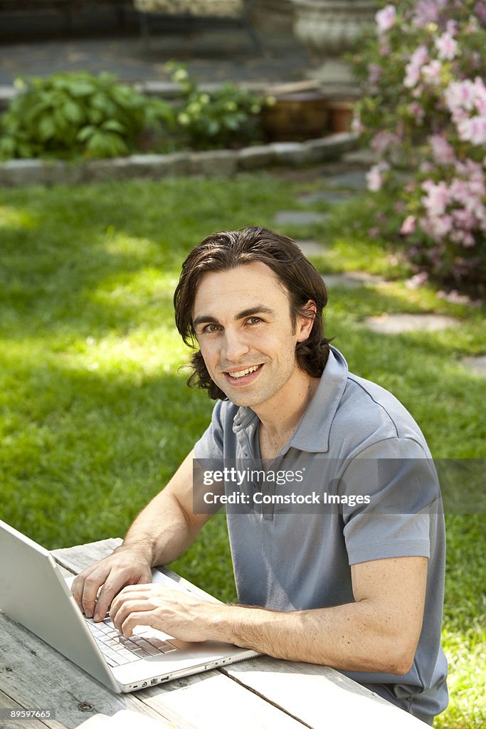 Man in backyard with computer