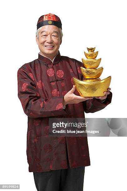 an elderly gentleman holds gold as a symbol of wealth and prosperity for chinese new year - the cheongsam stock pictures, royalty-free photos & images