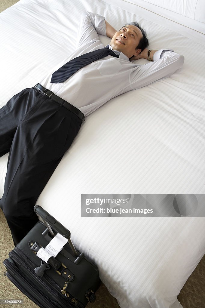 Man in business attire relaxing in bed