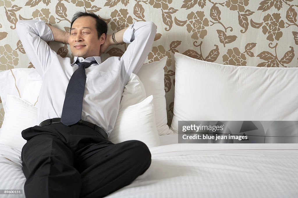 Man in business attire relaxing in bed