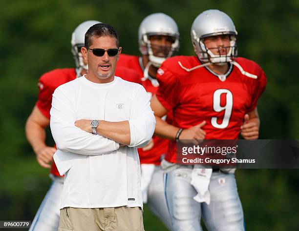 Head coach Jim Schwartz looks on while Matthew Stafford and Daunte Culpepper warm up during training camp at the Detroit Lions Headquarters and...