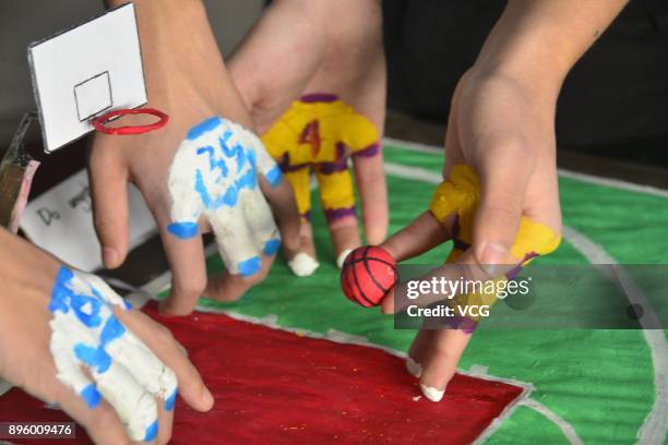 College student volunteers play mini basketball with painted fingers to welcome International Basketball Day at Liaocheng University on December 20,...