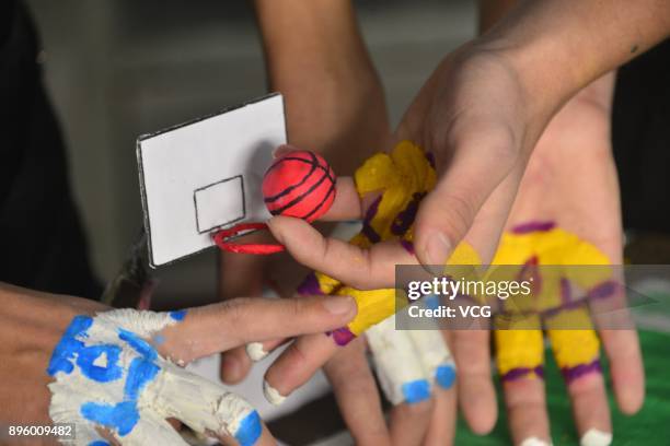 College student volunteers play mini basketball with painted fingers to welcome International Basketball Day at Liaocheng University on December 20,...