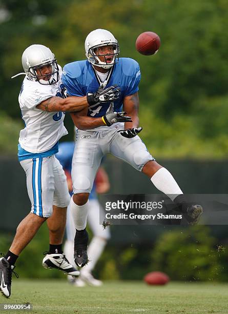Demir Boldin of the Detroit Lions tries to catch a pass in front of Chris Roberson during training camp at the Detroit Lions Headquarters and...