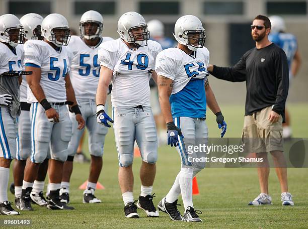 Larry Foote and Zack Follett of the Detroit Lions get ready to run drills with linbacker coach Matt Burke looking on during training camp at the...