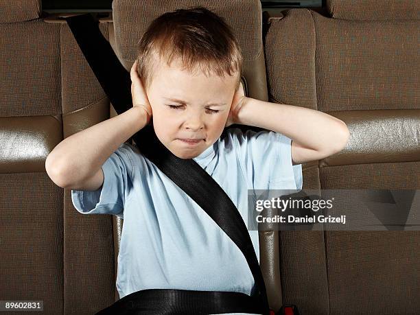 boy in car with eyes closed, hands covering ears - hand to ear photos et images de collection