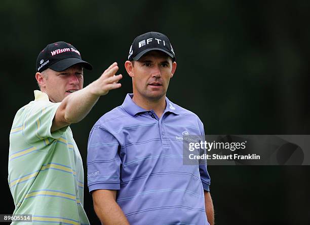 Padraig Harrington of Ireland and caddie Ronan Flood talk during a practice round of the World Golf Championship Bridgestone Invitational on August...