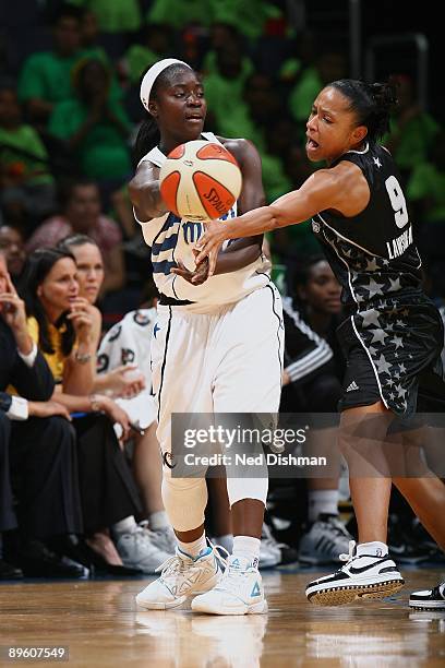 Matee Ajavon of the Washington Mystics passes against Edwige Lawson-Wade of the San Antonio Silver Stars during the game at the Verizon Center on...