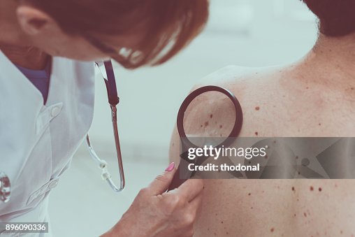 Dermatologist examining the skin of a patient Dermatologist examining the skin of a patient