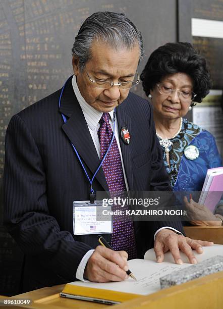 Former Malaysian prime minister Mahathir Mohamad and his wife Siti Hasmah Mohamad Ali sign a visitors book after his trip to the Peace Memorial...