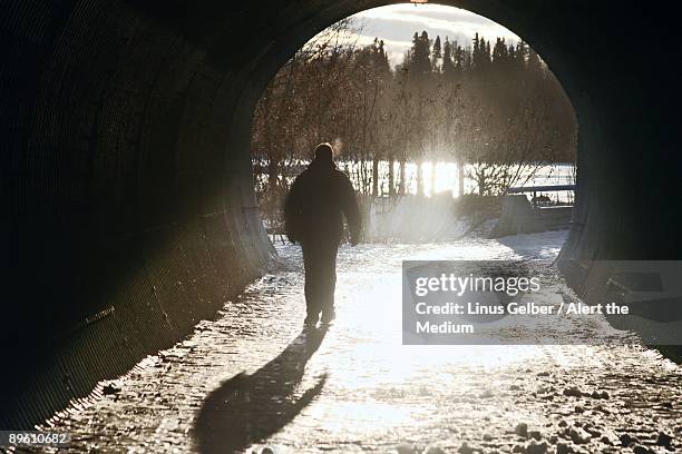 man walking into sunshine - anchorage foto e immagini stock