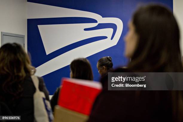 United States Postal Service signage stands past customers at the USPS Suburban post office station in Gaithersburg, Maryland, U.S., on Tuesday, Dec....