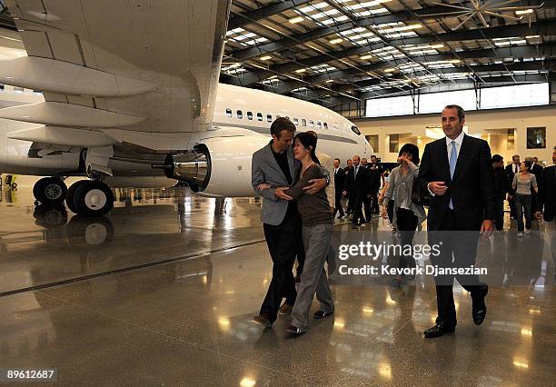 Journalists Laura Ling hugs husband Iain Clayton as Ling arrives with Euna Lee at Hangar 25 on August 5, 2009 in Burbank, California after being...