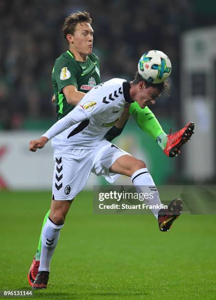 Ludwig Augustinsson of Bremen is challenged by Pascal Stenzel of Freiburg during the DFB Cup match between Werder Bremen and SC Freiburg at...