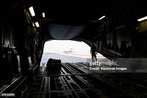 wide angle view of the front end of a c-17 globemaster iii preparing for takeoff on the tarmac of a united states air force base in qatar. - military crate stock pictures, royalty-free photos & images