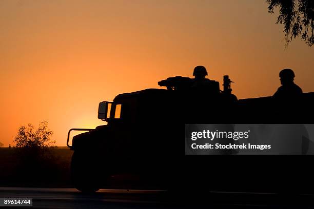 camp speicher, iraq - a us army humvee with soldiers in the back at sunset. - camp speicher stockfoto's en -beelden