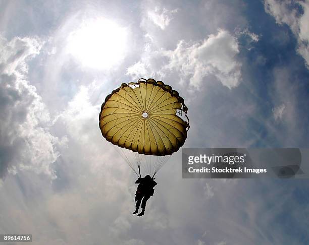 a paratrooper descends through the sky. - paratrooper bildbanksfoton och bilder