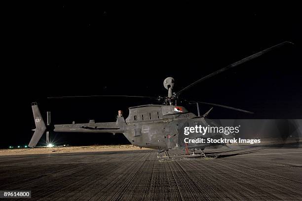 tikrit, iraq - an oh-58d kiowa sits on its pad at night. - camp speicher stockfoto's en -beelden