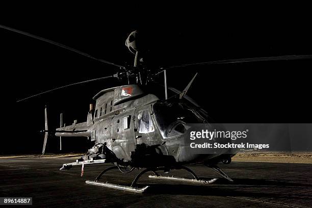 tikrit, iraq - an oh-58d kiowa sits on its pad at night. - camp speicher stock pictures, royalty-free photos & images