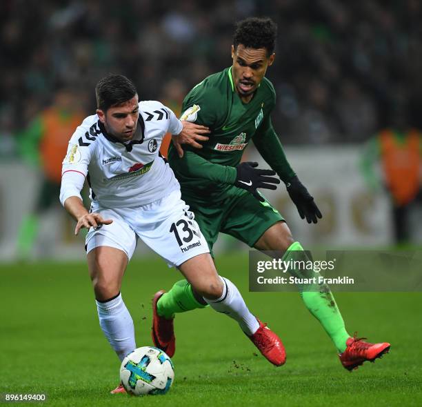 Theodor Gebre Selassie of Bremen is challenged by Marco Terrazzino of Freiburg during the DFB Cup match between Werder Bremen and SC Freiburg at...