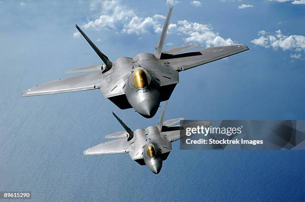 march 9, 2009 - two f-22 raptors fly over the pacific ocean during a theater security mission as part of a deployment to andersen air force base, guam.  - raptors stockfoto's en -beelden